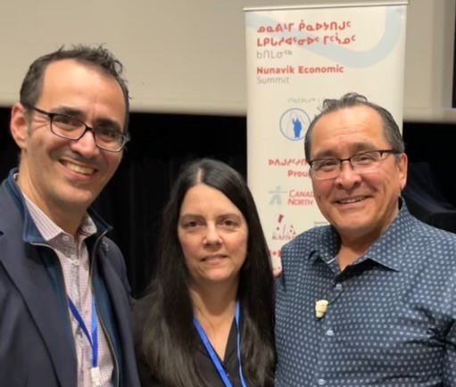 David Tordjman, DG de Nunavik Investment Corporation, Sandra Lafleur, directrice du BA ATNdQ et Pita Aatami, président de Makivvik posent ensemble lors d’un événement professionnel devant un panneau institutionnel. Ils portent des tenues professionnelles et des badges d’événement.